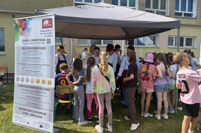 grupa młodzieży i uczniów szkoły podstawowej na festynie