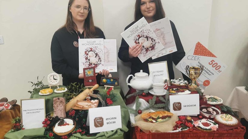 nagrodzone uczennice na tle swoich prac