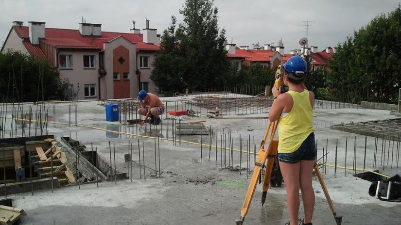 Na zdjęciu uczniowie zawodu technik geodeta wykonujący pomiary na dachu budynku.