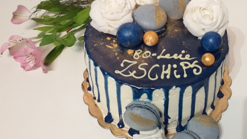 Zdjęcie przedstawia tort z dekoracją w kolorach biało niebieskich z napisem 80-lecie ZSCHIPS